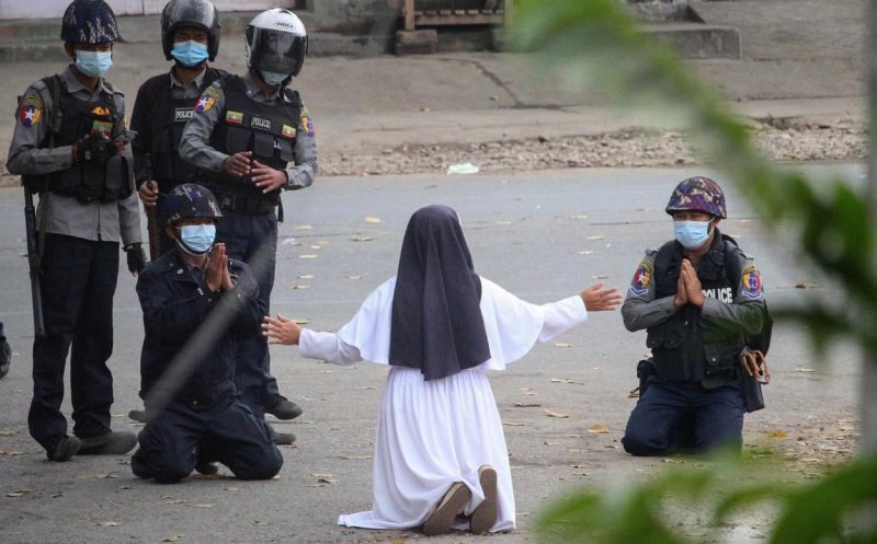 O călugăriță s-a așezat în genunchi în fața polițiștilor, la un protest. Doi oameni au murit la picioarele ei
