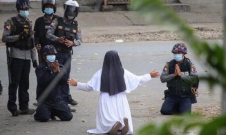 O călugăriță s-a așezat în genunchi în fața polițiștilor, la un protest. Doi oameni au murit la picioarele ei